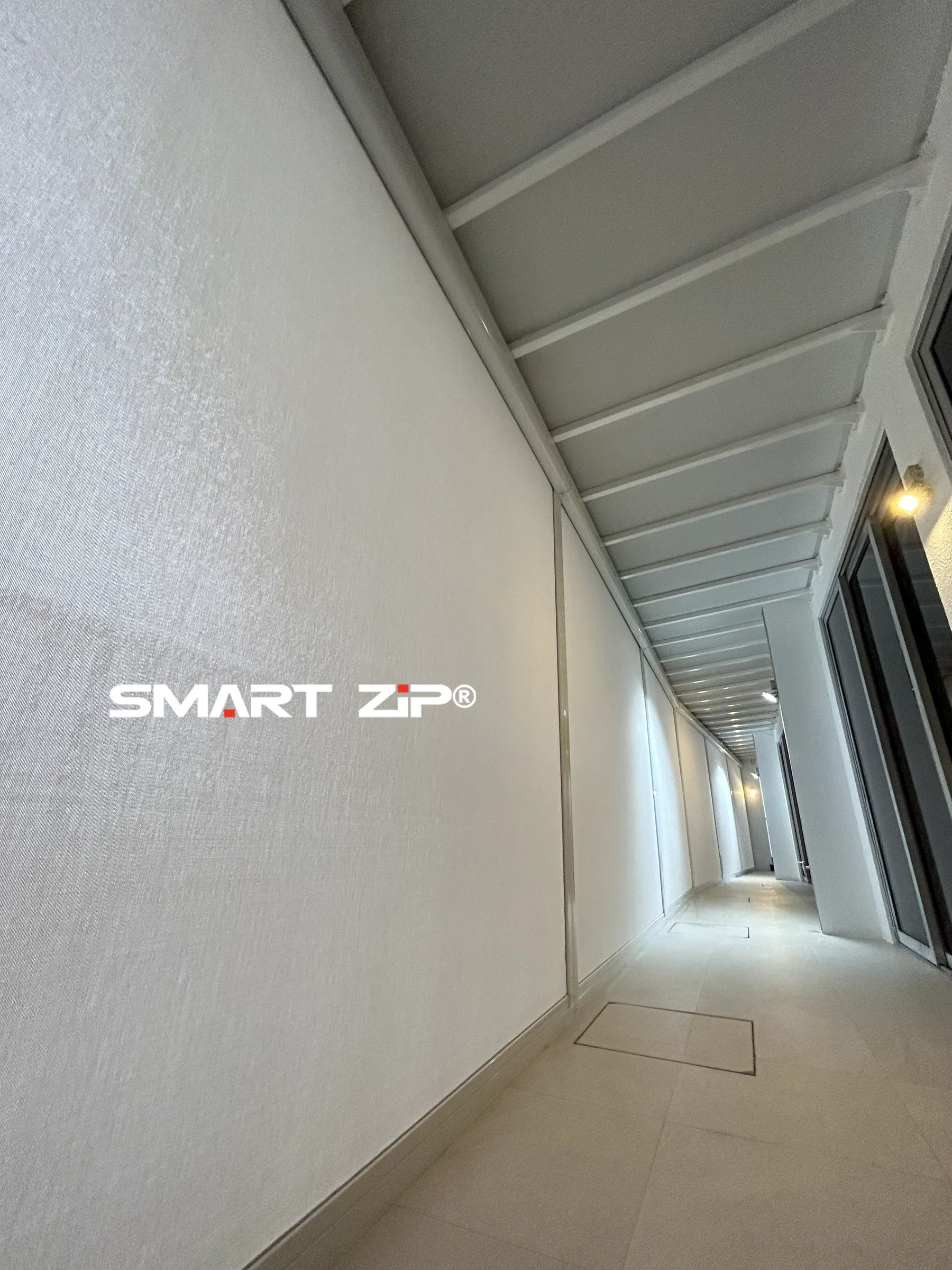 SmartZip outdoor blinds covering a long sheltered balcony opening