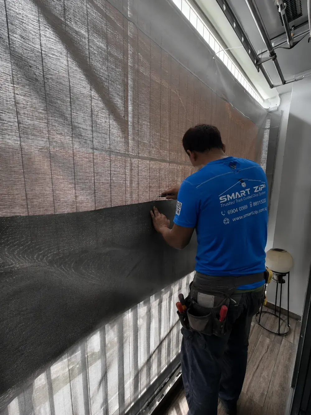 SmartZip technician repairing problematic Ziptrack fabric in Singapore