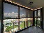 SmartZip screen blinds across a high-floor Singapore balcony with a filtered city view.