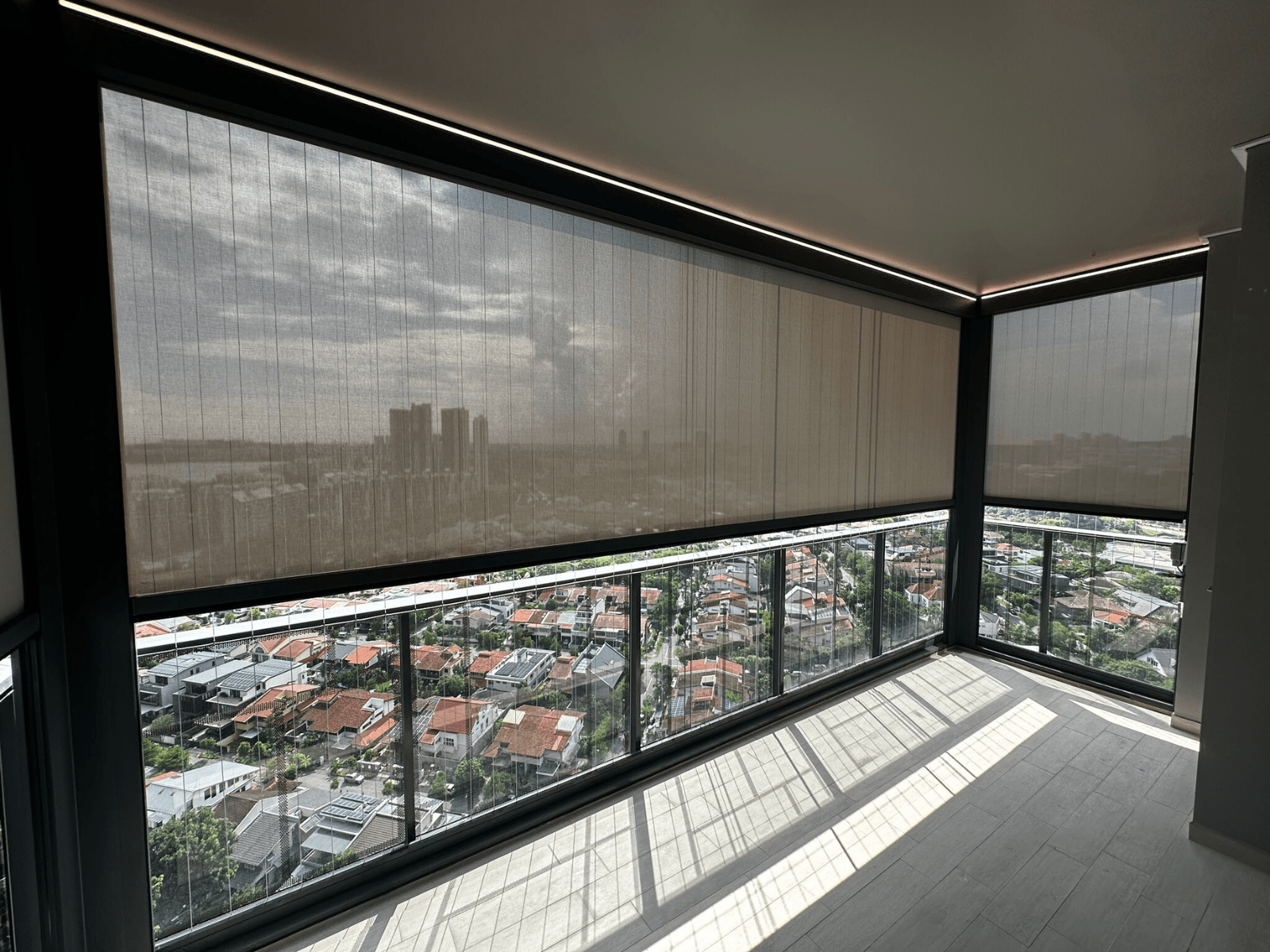 Close view of SmartZip fabric screens and top guide tracks on a high-floor balcony.