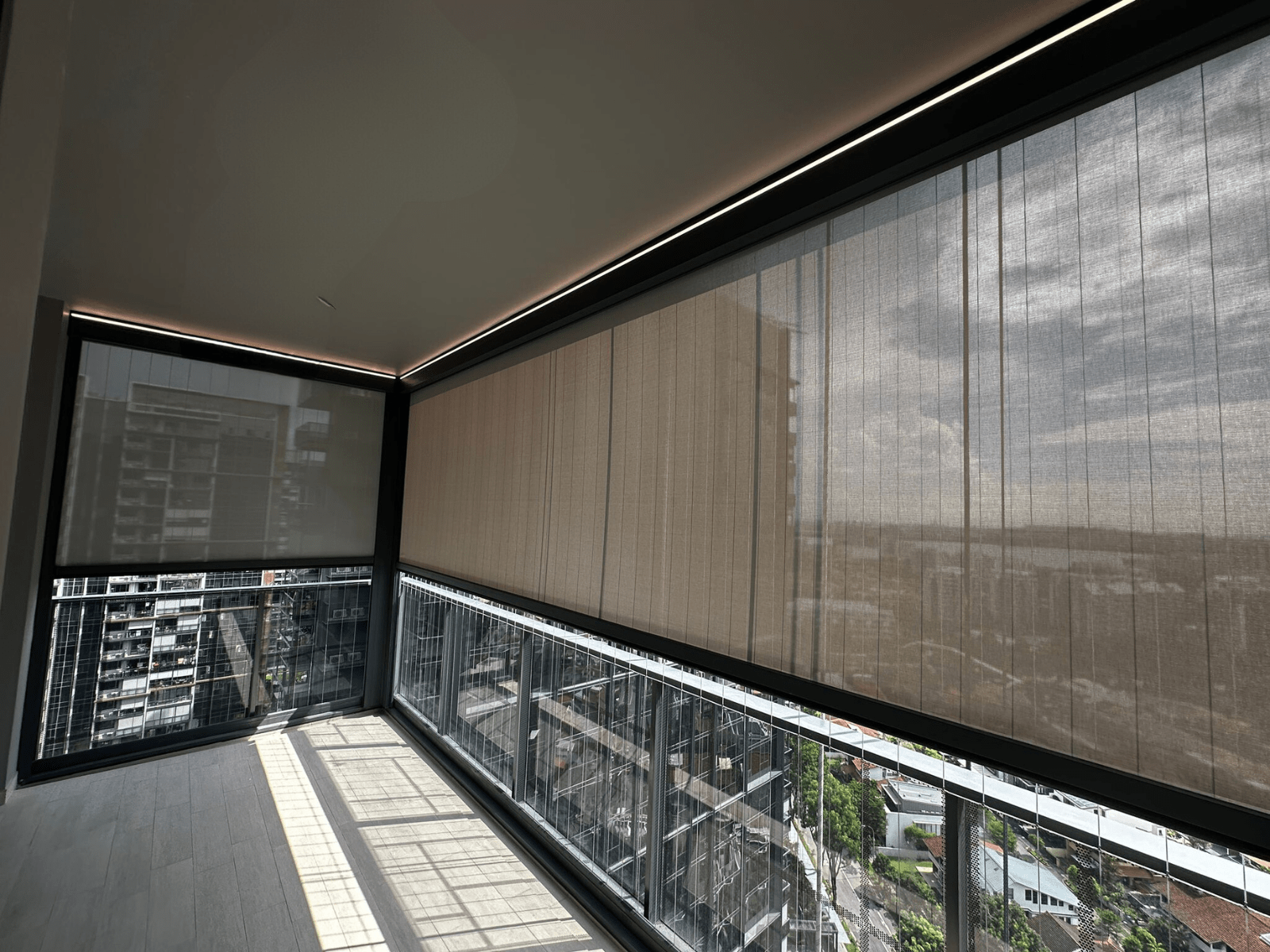 Side view of a SmartZip screen blind across a glass-railed corner balcony.